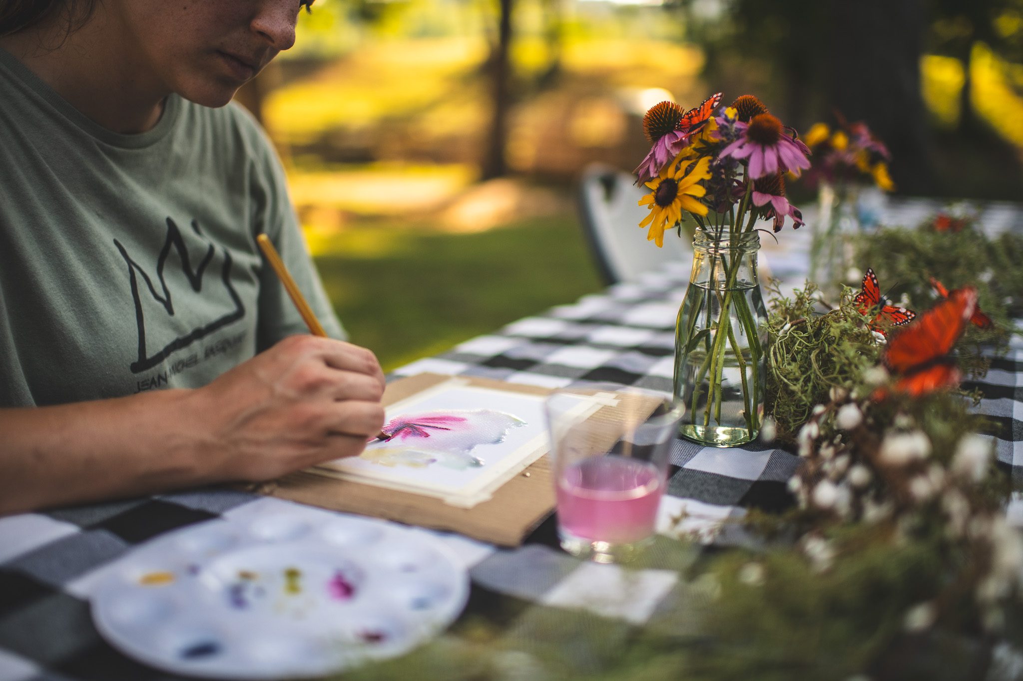 girls painting watercolor with flowers in the background